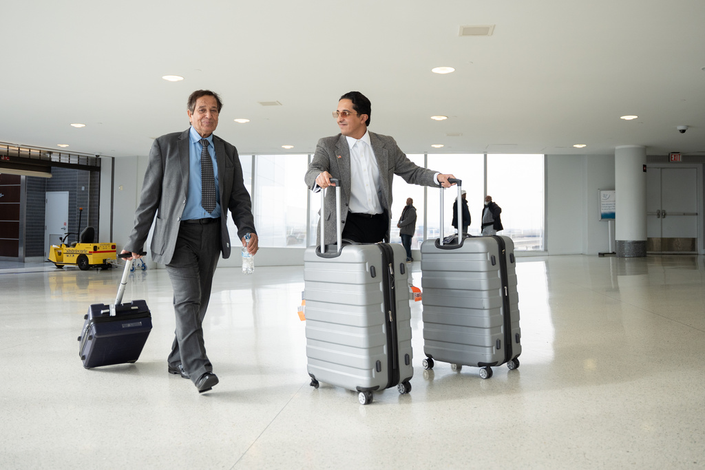 Father-son duo Saad and Ibrahim Almadi exit from the Philadelphia International Airport International Arrivals Hall on Thursday, Nov. 20, 2025, in Philadelphia. (AP Photo/Mingson Lau)