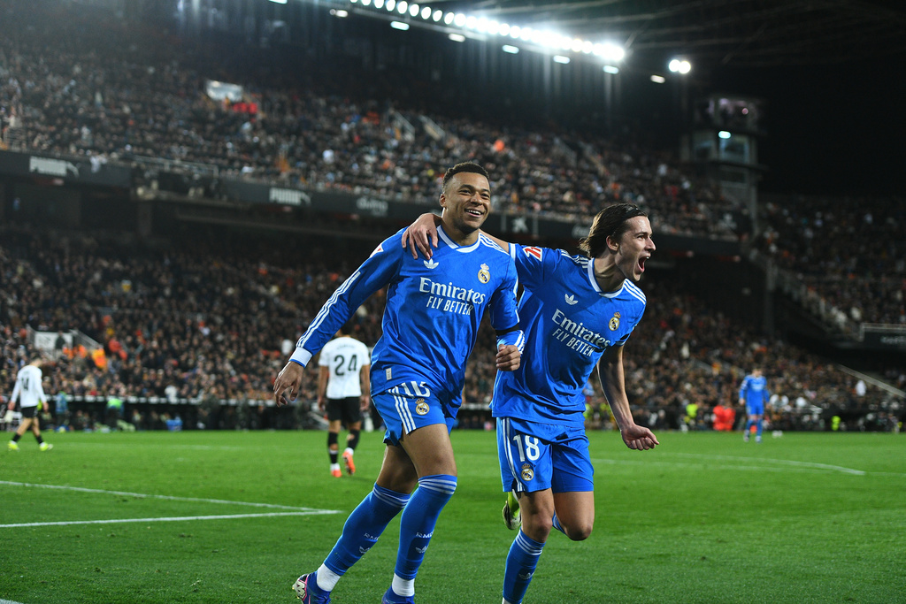 Real Madrid's Kylian Mbappe, left, celebrates with Alvaro Carreras after scoring his side's second goal during the Spanish La Liga soccer match between Valencia and Real Madrid in Valencia, Spain, Sunday, Feb. 8, 2026. (AP Photo/Francisco Macia)