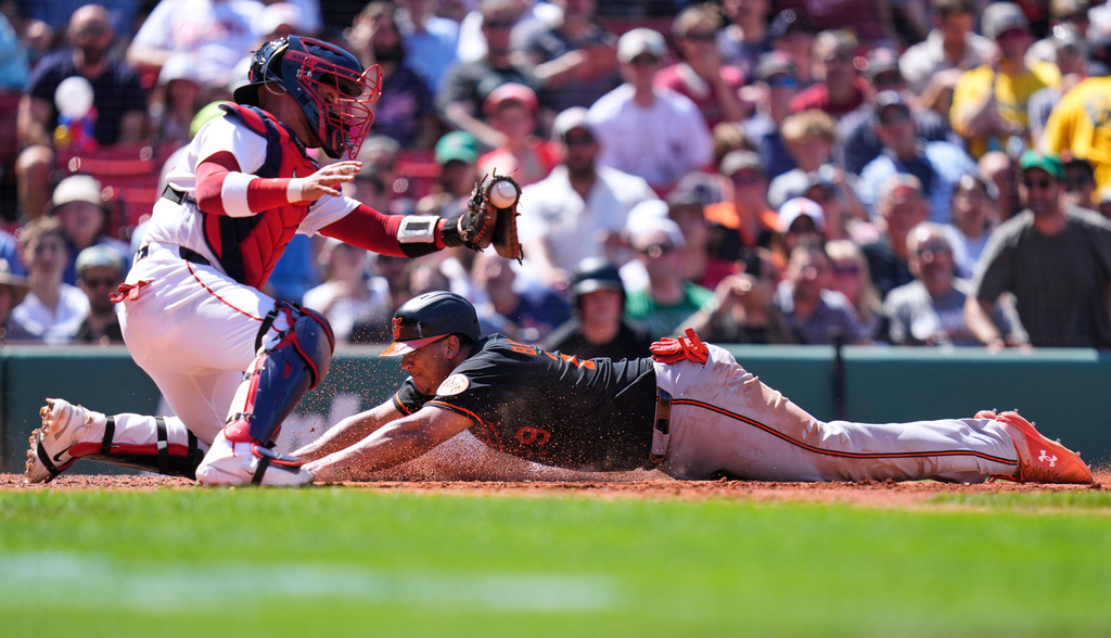 Baltimore Orioles' Samuel Basallo, right, beats the tag by Boston Red Sox's Carlos Narváez to score on a sacrifice by Colton Cowser during the fifth inning of a baseball game, Thursday, June 4, 2026, in Boston. (AP Photo/Charles Krupa)
