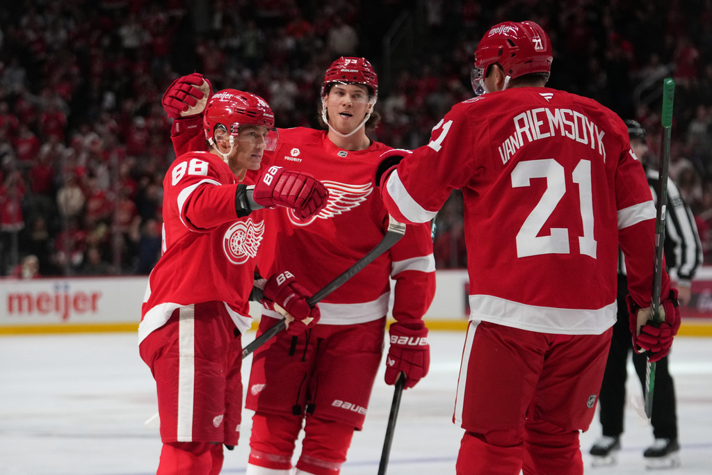 Detroit Red Wings right wing Patrick Kane (88) celebrates his goal with Moritz Seider and James van Riemsdyk (21) against the Florida Panthers in the second period of an NHL hockey game Wednesday, Oct. 15, 2025, in Detroit. (AP Photo/Paul Sancya)