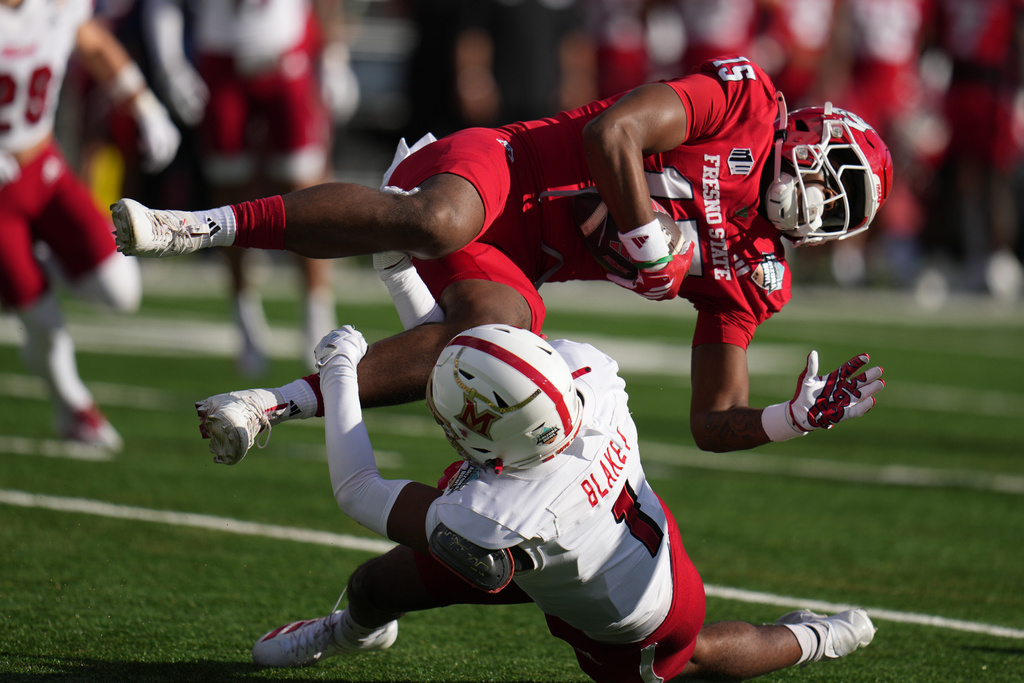 Miami (Ohio) defensive back Eli Blakey, bottom, upends Fresno State tight end Kamron Beachem (15) in the first half of the Snoop Dogg Arizona Bowl NCAA college football game, Saturday, Dec. 27, 2025, in Tucson, Ariz. (AP Photo/Rick Scuteri)