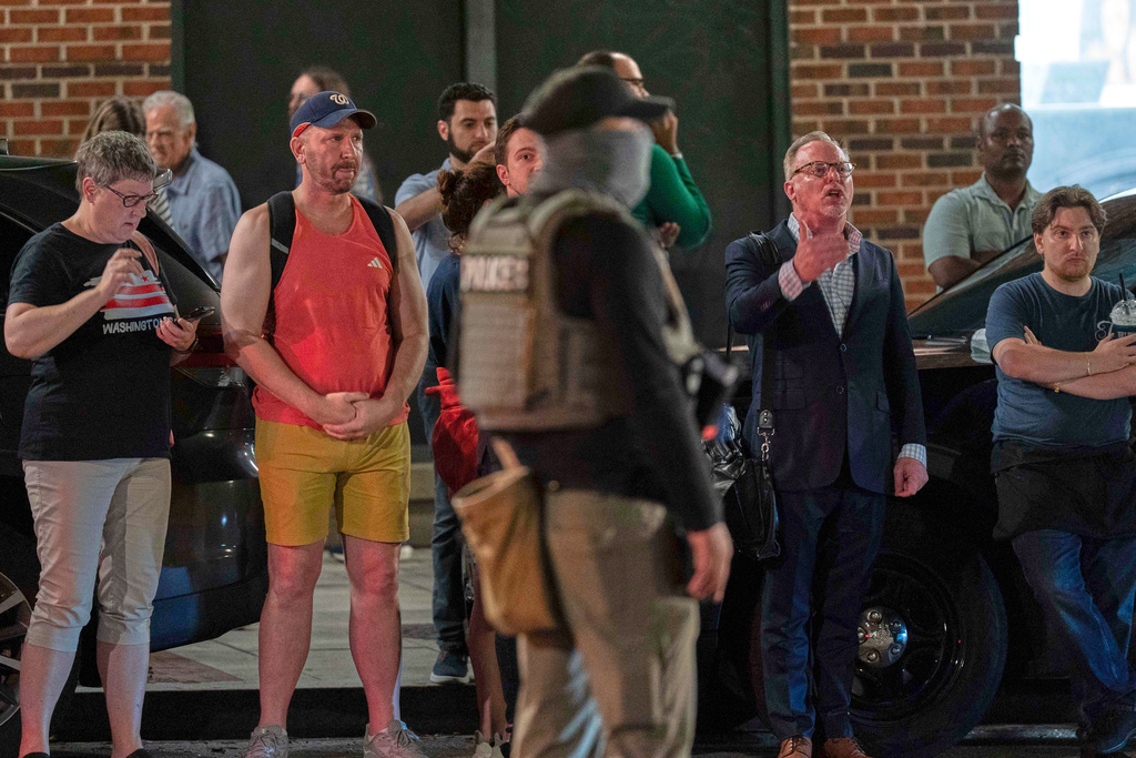 Residents of the area yell at agents of the Department of Homeland Security Investigations as they join Washington Metropolitan Police Department officers to conduct traffic checks at a checkpoint along 14th Street in northwest Washington, Wednesday, Aug. 13, 2025, in Washington. (AP Photo/Jose Luis Magana)