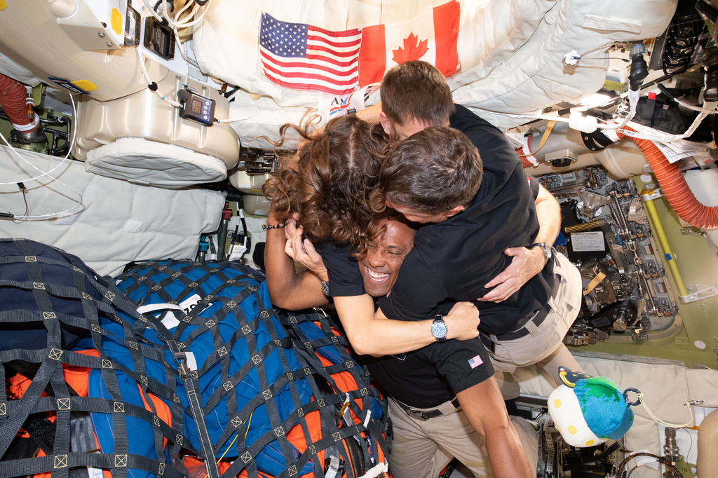 In this image provided by NASA, The Artemis II crew, clockwise from left, Mission Specialist Christina Koch, Mission Specialist Jeremy Hansen, Commander Reid Wiseman, and Pilot Victor Glover, take time out for a group hug inside the Orion spacecraft on their way home on Wednesday, April 7, 2026. (NASA via AP)