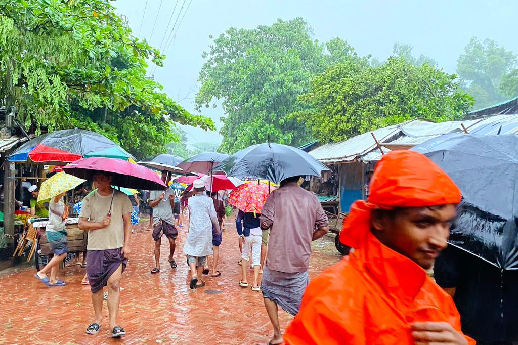 People walk through rain at a Rohingya refugee camp in Cox's Bazar, Bangladesh, Tuesday, July 7, 2026. (AP Photo/Shamimul Islam Faisal)