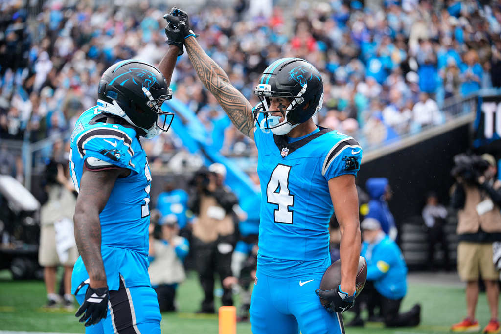 Carolina Panthers' Xavier Legette, left, and Tetairoa McMillan (4) celebrates after McMillan caught a touchdown pass in the first half of an NFL football game against the Dallas Cowboys Sunday, Oct. 12, 2025, in Charlotte, N.C. (AP Photo/Jacob Kupferman)