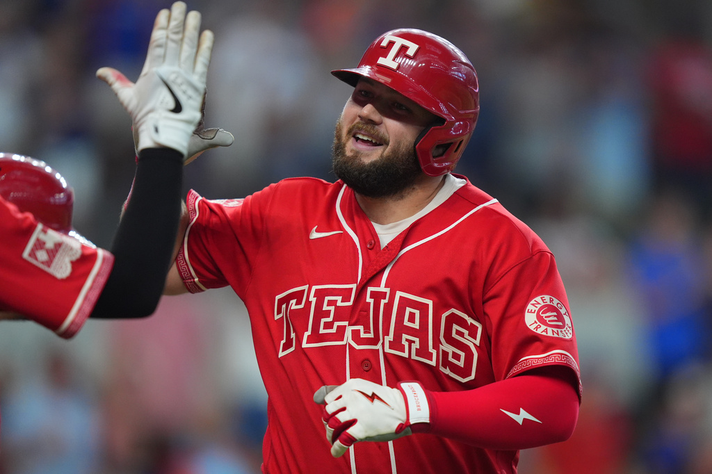 Texas Rangers' Jake Burger celebrates after his home home run that also scored teammate Jarred Kelenic during the seventh inning of a baseball game against the San Diego Padres, Saturday, June 20, 2026, in Arlington, Texas. (AP Photo/LM Otero)
