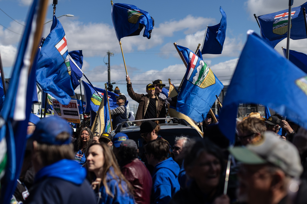 Supporters fly flags in support of Mitch Sylvestre as he submits his signatures for a separation referendum to Elections Alberta in Edmonton, on Monday, May 4, 2026. (Jason Franson/The Canadian Press via AP)
