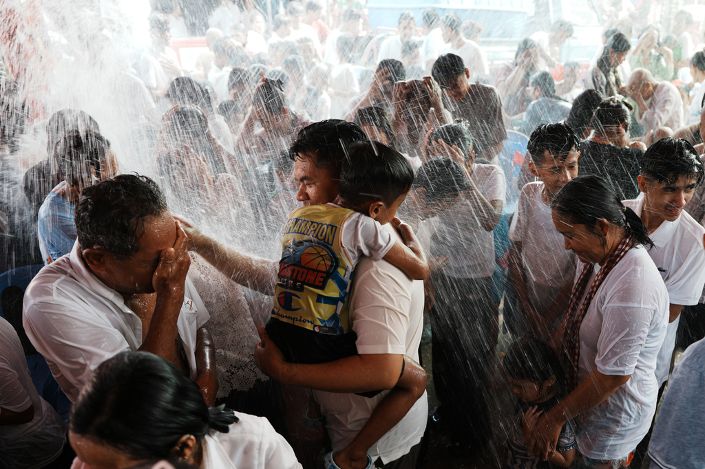 Local residents of Prey Popel village receive a holy water shower, which is believed to bring good luck, during Khmer New Year celebrations on the outskirts of Phnom Penh, Cambodia, Sunday, April 12, 2026. (AP Photo/Heng Sinith)