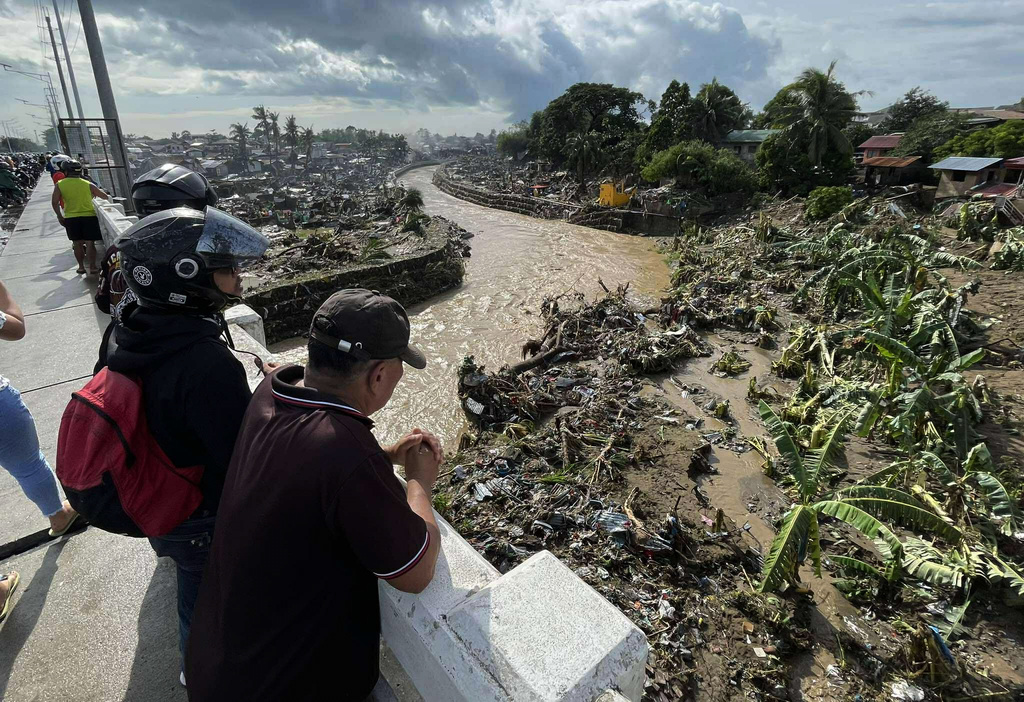 Men look at damaged homes after Typhoon Kalmaegi caused devastation in communities along the Mananga River in Talisay City, Cebu province, central Philippines, Wednesday, Nov. 5, 2025. (AP Photo/Jacqueline Hernandez)