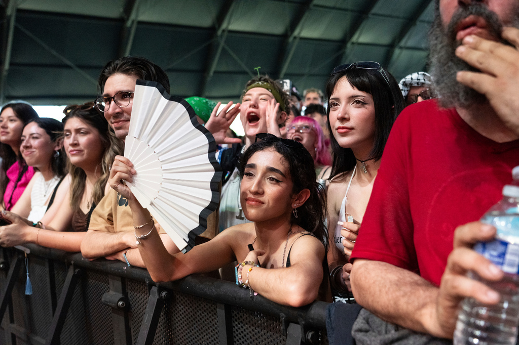 FILE - A festivalgoer holds a fan at the Coachella Valley Music and Arts Festival in Indio, Calif., on April 11, 2025. (Photo by Amy Harris/Invision/AP, File)