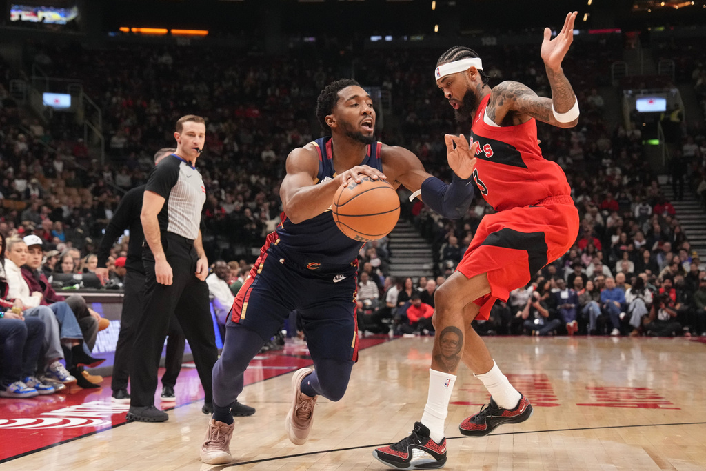 Cleveland Cavaliers guard Donovan Mitchell drives at Toronto Raptors forward Brandon Ingram (during the first half of an NBA basketball game in Toronto on Monday Nov. 24, 2025. (Chris Young/The Canadian Press via AP)