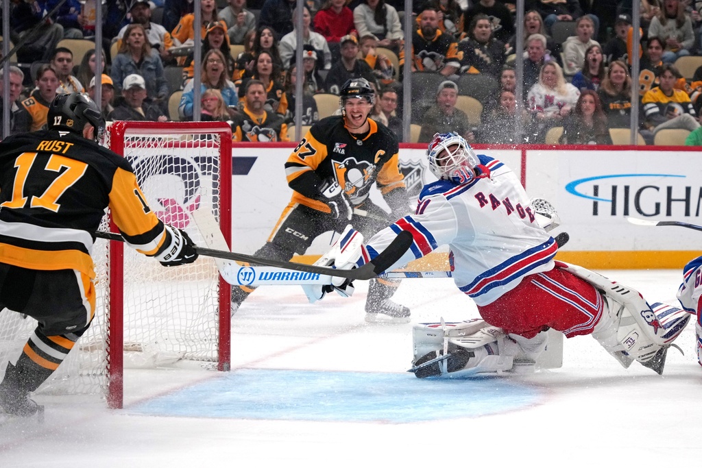 Pittsburgh Penguins' Sidney Crosby, center, and Bryan Rust (17) can't get the puck past New York Rangers goaltender Igor Shesterkin (31) the second period of an NHL hockey game in Pittsburgh, Saturday, Oct. 11, 2025. (AP Photo/Gene J. Puskar)
