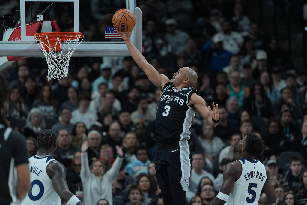 San Antonio Spurs forward Keldon Johnson (3) scores past Minnesota Timberwolves guard Anthony Edwards (5) during the second half of an NBA basketball game in San Antonio, Saturday, Jan. 17, 2026. (AP Photo/Eric Gay)
