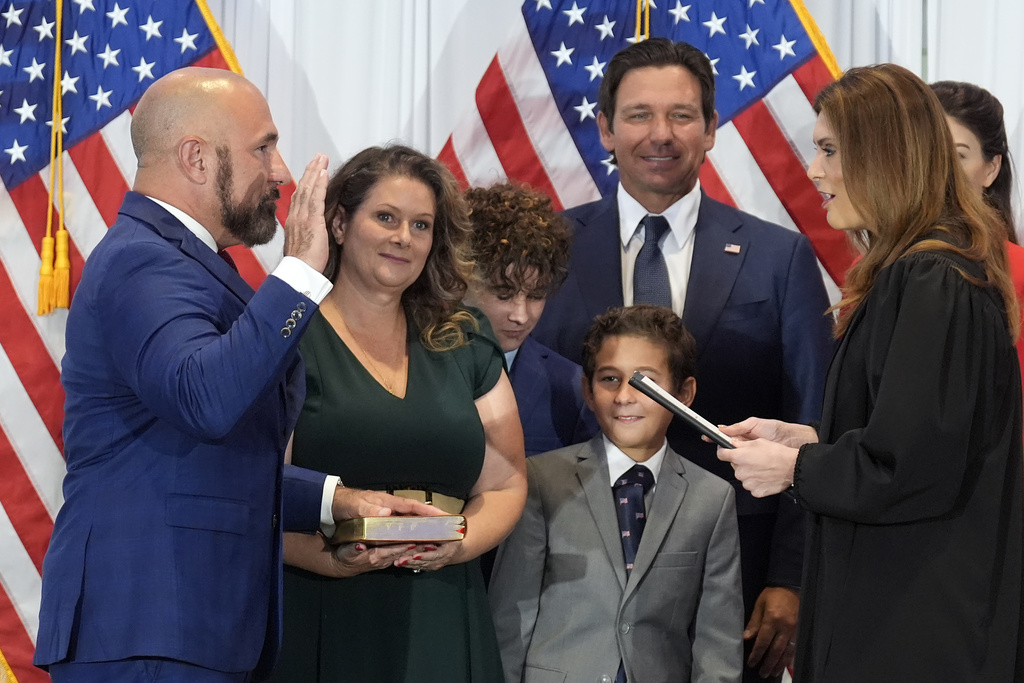 Florida Sen. Jay Collins, (R-District 14) left, surrounded by family members and Governor Ron DeSantis, takes the oath of office after being named the new Lieutenant Governor of Florida during a news conference Tuesday, Aug. 12, 2025, in Tampa, Fla. (AP Photo/Chris O'Meara)