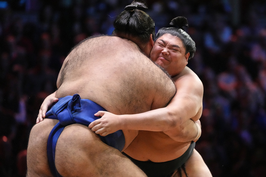 Sumo wrestlers, called rikishi, Takayasu, rear, and Abi push during their bout on the dohyo, the sacred sumo wrestling ring, during The Grand Sumo Tournament at the Royal Albert Hall in London, Wednesday, Oct. 15, 2025. (AP Photo/Frank Augstein)