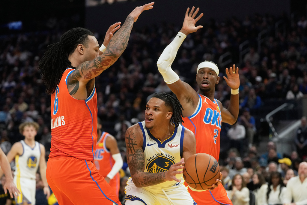 Golden State Warriors guard Will Richard (3) looks to pass the ball between Oklahoma City Thunder forward Jaylin Williams, left, and guard Shai Gilgeous-Alexander during the first half of an NBA basketball game in San Francisco, Tuesday, Dec. 2, 2025. (AP Photo/Jeff Chiu)