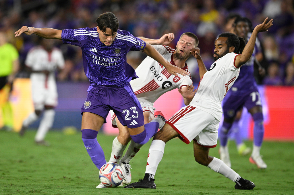 Orlando City forward Harvey Sarajian (23) competes for the ball against Toronto FC defender Walker Zimmerman, center, and defender Raheem Edwards, right, during the second half of an MLS soccer match, Saturday, Sept. 12, 2026, in Orlando, Fla. (AP Photo/Phelan M. Ebenhack)