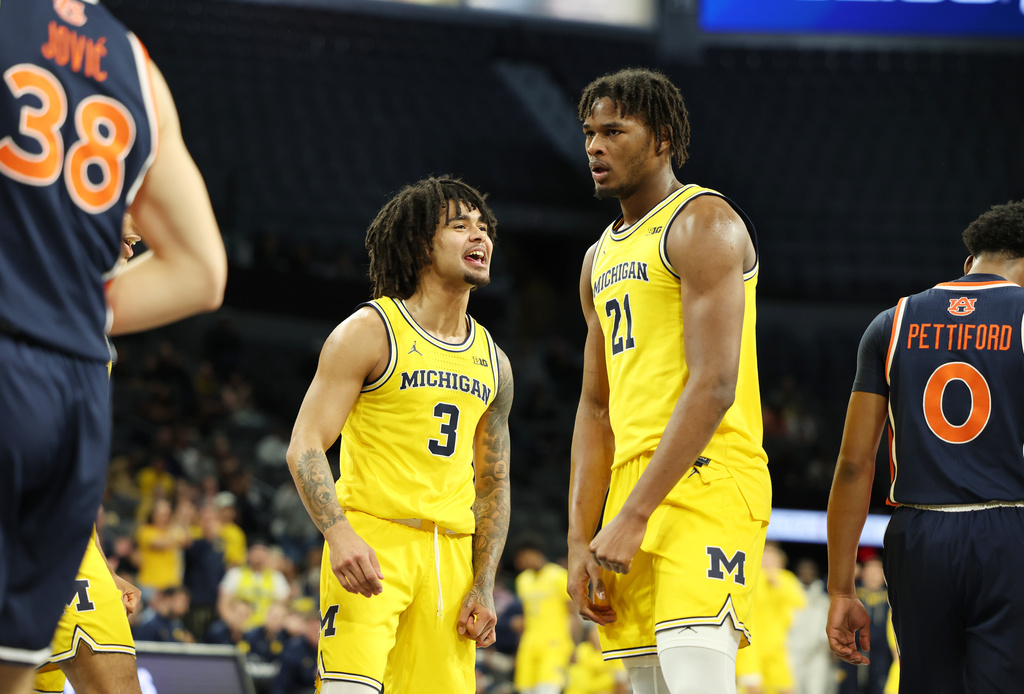 Michigan guard Elliot Cadeau (3) and forward Morez Johnson Jr. (21) react to a play during the first half of an NCAA college basketball game against Auburn Tuesday, Nov. 25, 2025, in Las Vegas. (AP Photo/Ronda Churchill)