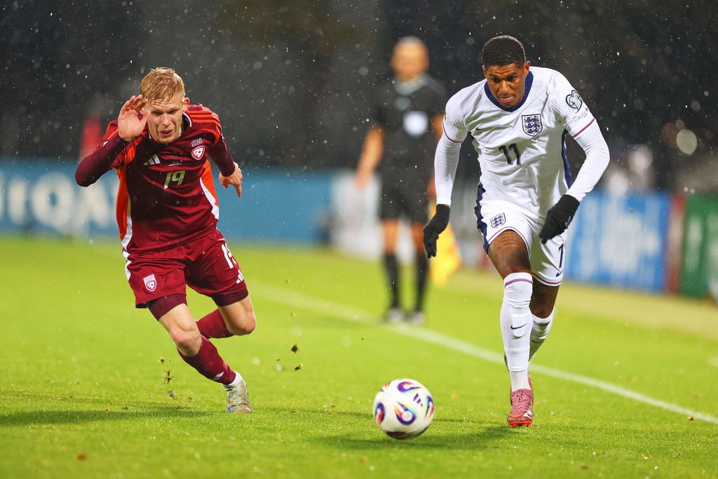 England's Marcus Rashford, right, and Latvia's Maksims Tonisevs in action during the 2026 World Cup group K qualifying soccer match between Latvia and England in Riga, Latvia, Tuesday, Oct. 14, 2025. (AP Photo/Roman Koksarov)