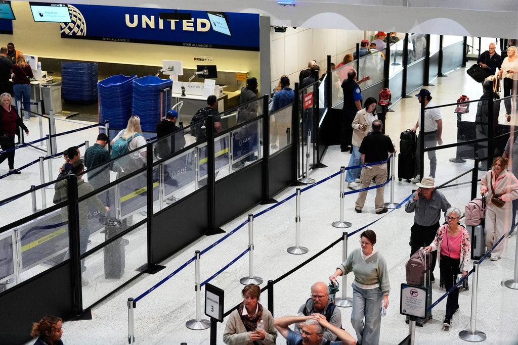 Travelers stand in line at a security checkpoint at George Bush Intercontinental Airport on Friday, Nov. 7, 2025, in Houston. (AP Photo/Ashley Landis)