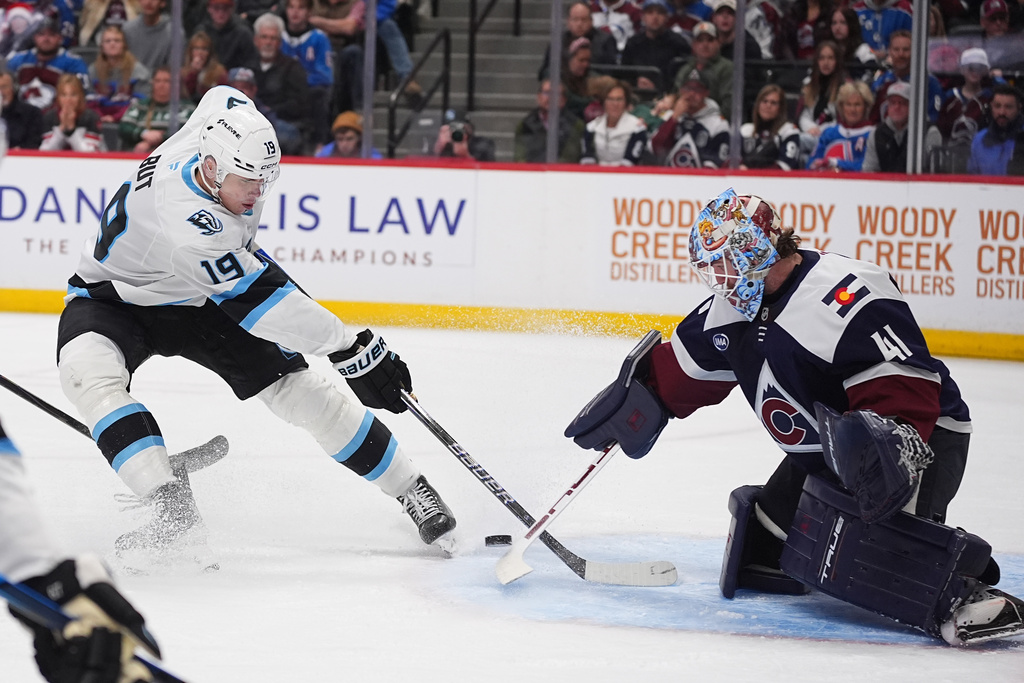 Colorado Avalanche goaltender Scott Wedgewood, right, stops a shot by Utah Mammoth left wing Daniil But in the second period of an NHL hockey game Tuesday, Dec. 23, 2025, in Denver. (AP Photo/David Zalubowski)