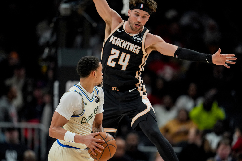 Milwaukee Bucks guard Ryan Rollins (13) looks to pass against Atlanta Hawks forward Corey Kispert (24) during the first half of an NBA basketball game, Monday, Jan. 19, 2026, in Atlanta. (AP Photo/Mike Stewart)