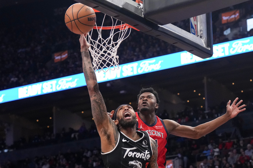 Toronto Raptors' Brandon Ingram, front, plays the ball as New Orleans Pelicans' Yves Missi defends during the first half of an NBA basketball game in Toronto on Friday March 27, 2026. (Chris Young/The Canadian Press via AP)