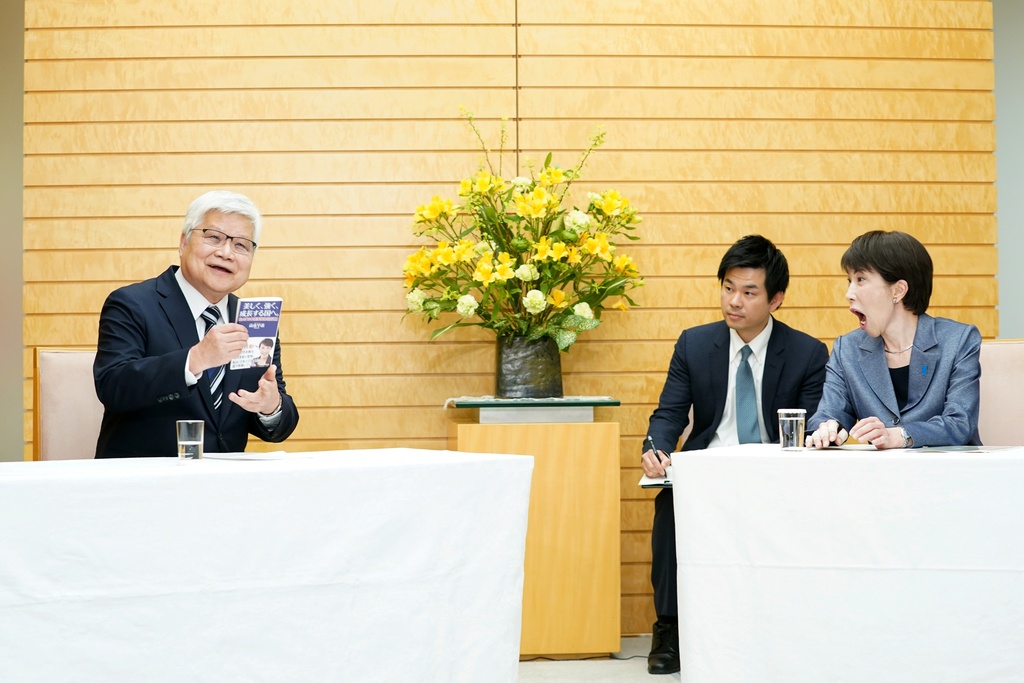Japanese Prime Minister Sanae Takaichi, right, reacts as Taiwan Semiconductor Manufacturing Company's Chairman C.C. Wei, left, brings out a book written by Takaichi during a meeting at the prime minister's office in Tokyo, Thursday, Feb. 5, 2026. (Kazuhiro Nogi/Pool Photo via AP)