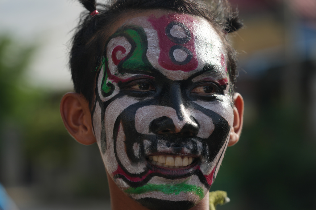A man with a ghost painting takes part in a ceremony to invoke rain amid the rice planting season in Pring Ka-ek village, northwest of Phnom Penh, Cambodia, Thursday, May 21, 2026. (AP Photo/Heng Sinith)