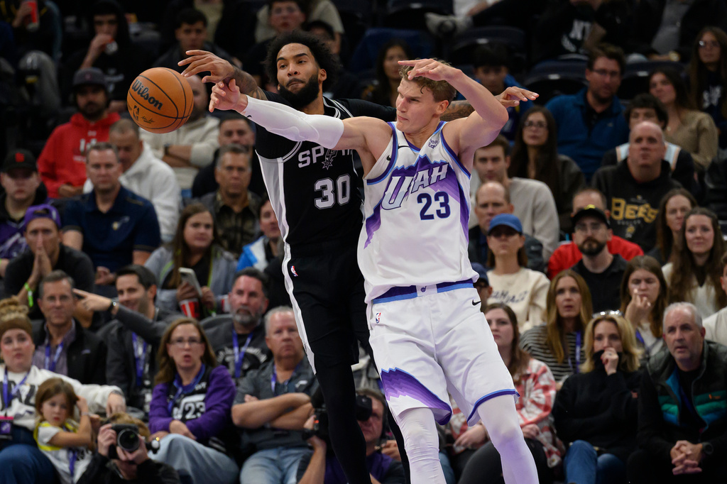 San Antonio Spurs forward Julian Champagnie (30) and Utah Jazz forward Lauri Markkanen (23) battle for the loose ball during an NBA basketball game, Monday, Oct. 12, 2026, in Salt Lake City. (AP Photo/Tyler Tate)