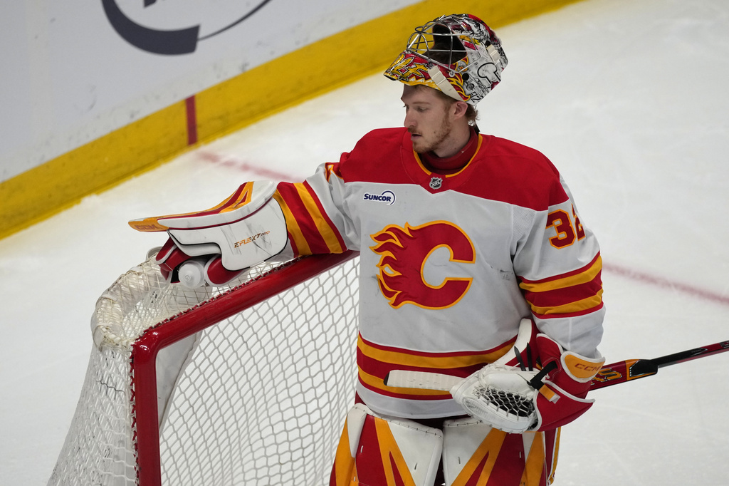 Calgary Flames goaltender Dustin Wolf reacts after giving up a goal to Colorado Avalanche center Jack Drury in the first period of an NHL hockey game, Monday, March 30, 2026, in Denver. (AP Photo/David Zalubowski)