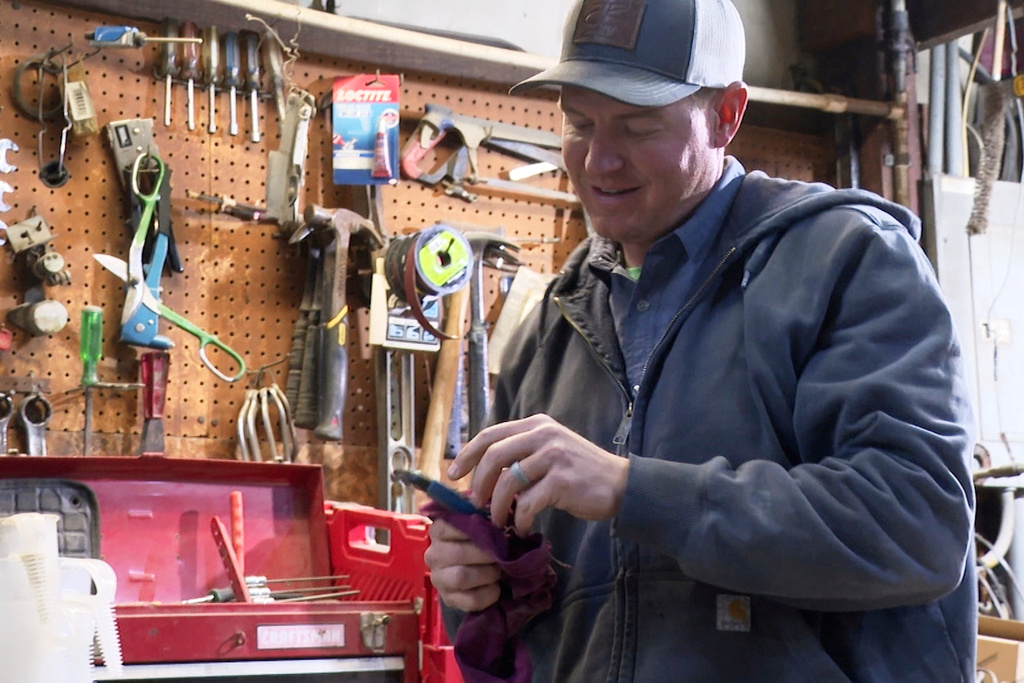 FILE - Bryant Kagay holds a tool in the workshop of the farm he co-owns with his father and grandfather in Amity, Missouri, April 4, 2025. (AP Photo/Nick Ingram, File)