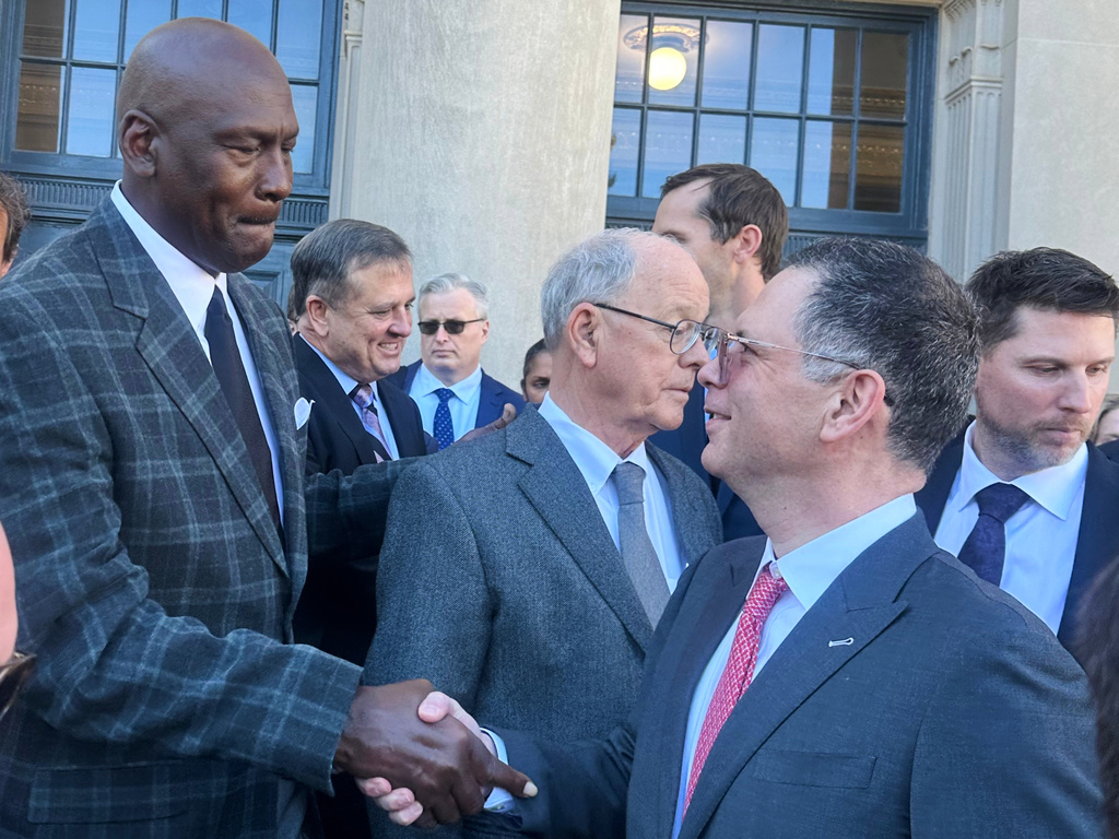 Michael Jordan, left, shakes hands with NASCAR attorney Lawrence Buterman as NASCAR chairman Jim France, center, looks away, Thursday, Dec. 11, 2025, outside the federal courthouse in Charlotte, N.C. (AP Photo/Jenna Fryer)