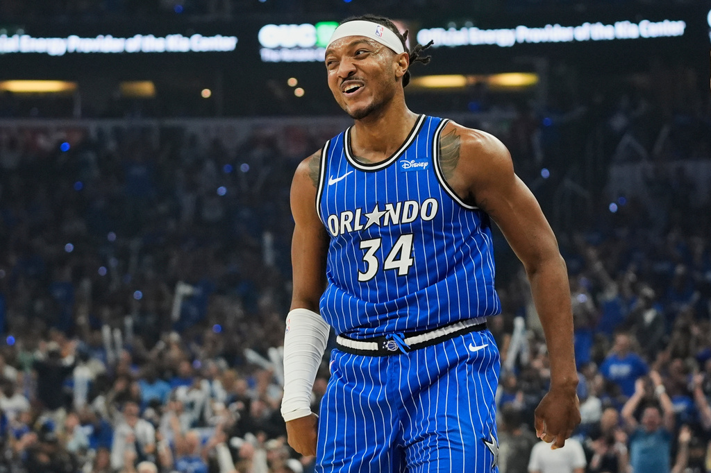 Orlando Magic center Wendell Carter Jr. (34) smiles to teammates after sinking a 3-point shot against the Charlotte Hornets during the first half of an NBA play-in tournament basketball game, Friday, April 17, 2026, in Orlando, Fla. (AP Photo/John Raoux)