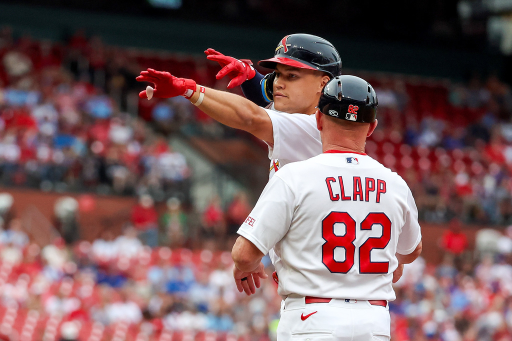 St. Louis Cardinals' JJ Wetherholt, left, gestures toward the dugout while first base coach Stubby Clapp (82) stands nearby after hitting a single during the first inning of a baseball game against the Chicago Cubs, Sunday, May 31, 2026, in St. Louis. (AP Photo/Scott Kane)