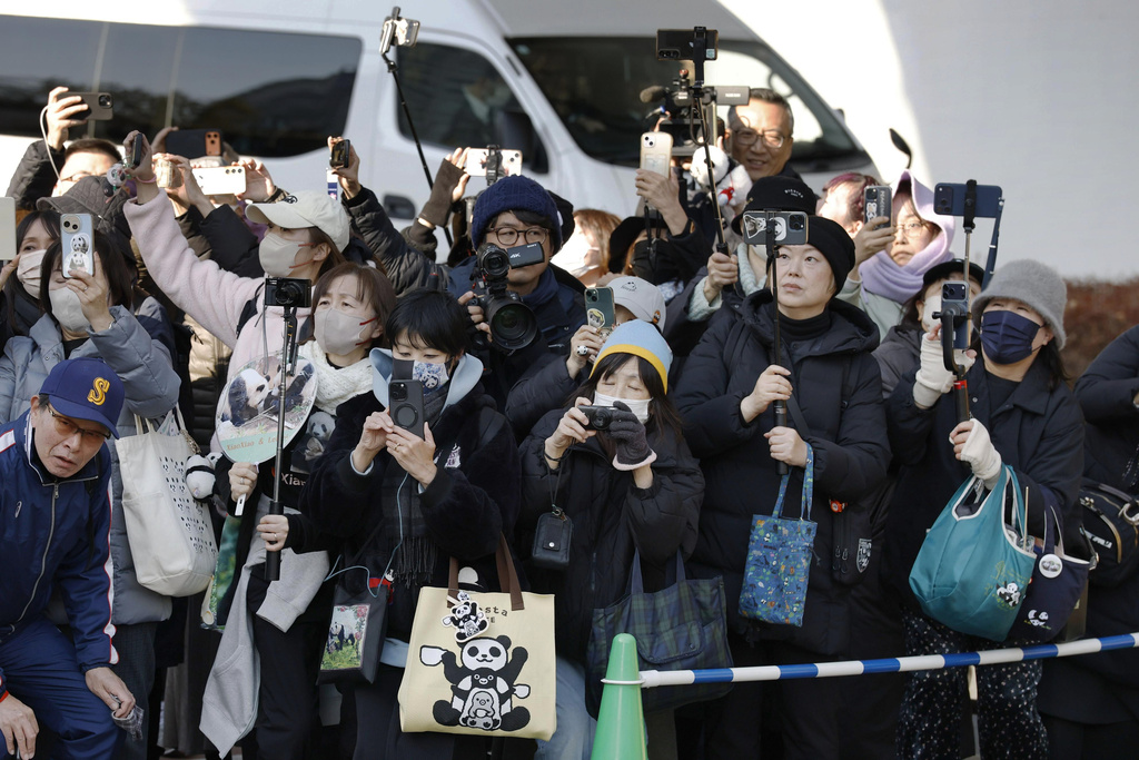 Panda fans gather as a vehicle, unseen, carrying Japan's last two giant pandas Xiao Xiao and Lei Lei departs Ueno zoo in Tokyo Tuesday, Jan. 27, 2026. (Shingo Fukuma/Kyodo News via AP)