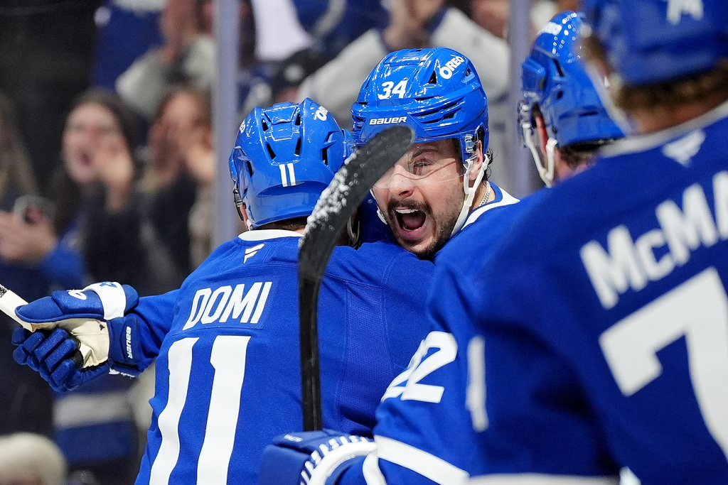 Toronto Maple Leafs center Auston Matthews (34) celebrates his goal with teammate Max Domi (11) during the second period of an NHL hockey game against the Ottawa Senators, in Toronto, Saturday, Dec. 27, 2025. (Frank Gunn/The Canadian Press via AP)