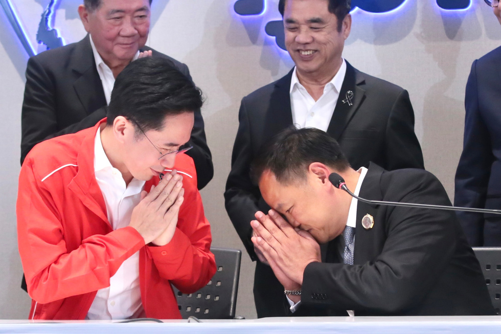 In this photo released by Bhumjaithai Party, Pheu Thai Party prime minister candidate Yodchanan Wongsawat, left, greets Thailand's Prime Minister and leader of Bhumjaithai Party Anutin Charnvirakul at Bhumjaithai, the party headquarters in Bangkok, Thailand, Friday, Feb. 13, 2026. (Bhumjaithai Party via AP)