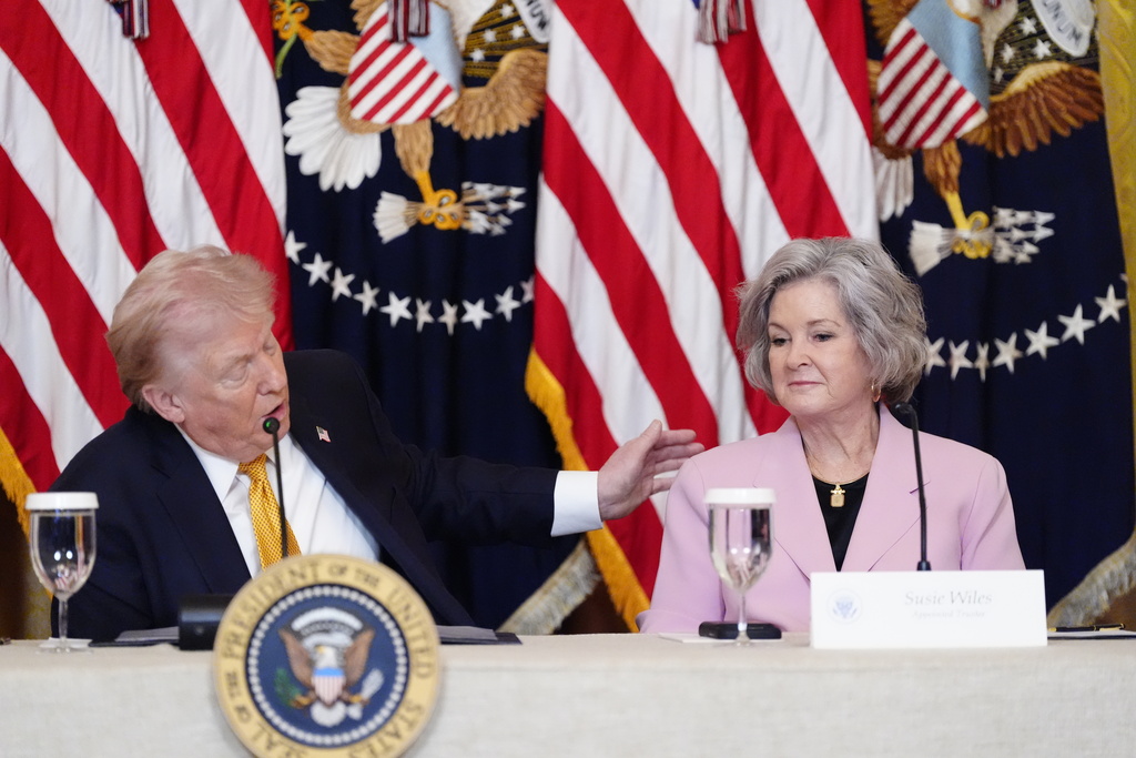 President Donald Trump speaks next to White House Chief of Staff Susie Wiles during a board meeting of the John F. Kennedy Memorial Center For The Performing Arts in the East Room of the White House, Monday, March 16, 2026, in Washington. (AP Photo/Alex Brandon)
