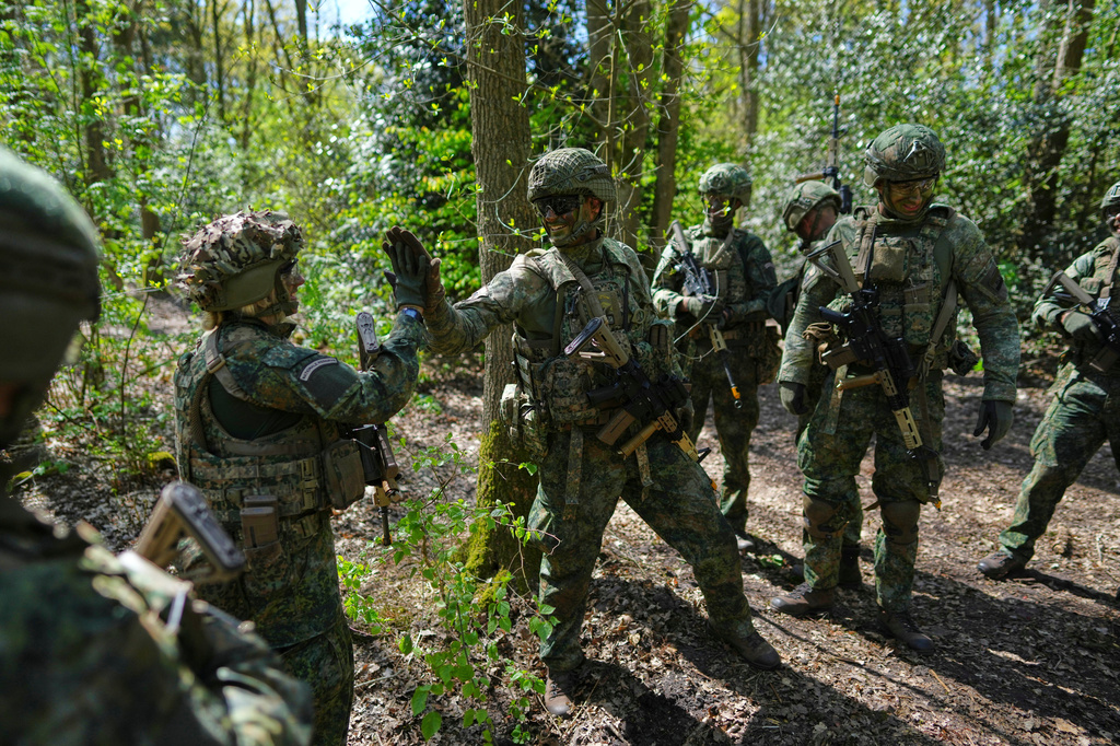 Members of the 10th Infantry Battalion Guard Security Corps National Reserve high-five after unearthing an enemy foxhole during a weekend exercise to hone their military skills as the Netherlands beefs up its military with new recruits and volunteer reservists in Havelte, Netherlands, Saturday, April 25, 2026. (AP Photo/Peter Dejong)