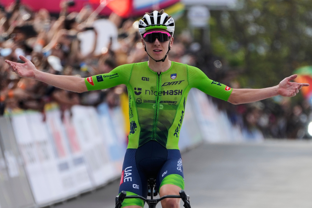 Slovenia's Tadej Pogacar celebrates winning the men's Elite road race, at the road cycling World Championships in Kigali, Rwanda, Sunday, Sept. 28, 2025. (AP Photo/Jerome Delay)