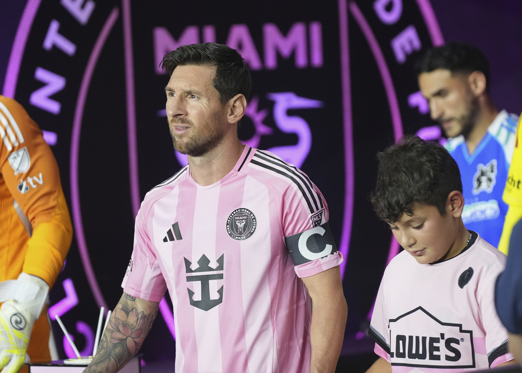 Inter Miami forward Lionel Messi, left, walks onto the field before an MLS soccer match against the Seattle Sounders, Tuesday, Sept. 16, 2025, in Fort Lauderdale, Fla. (AP Photo/Lynne Sladky)