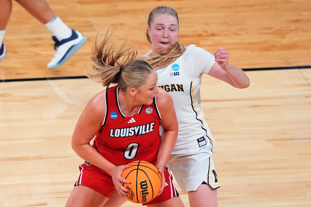 Louisville forward Laura Ziegler (0) looks to make a pass as Michigan guard Olivia Olson, right, defends in the first half in the Sweet 16 of the NCAA college basketball tournament, Saturday, March 28, 2026, in Fort Worth, Texas. (AP Photo/LM Otero)