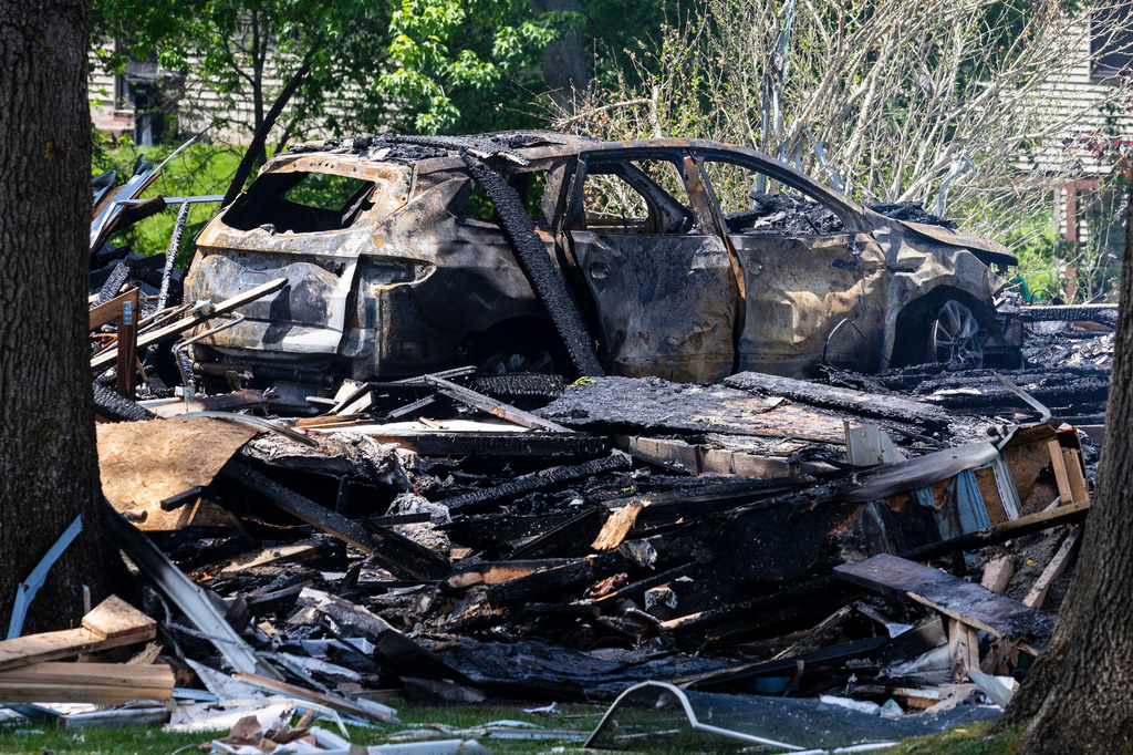 A burned vehicle lays among other debris after a house explosion in Comstock Park, Mich. on Tuesday, May 26, 2026. (Joel Bissell/Kalamazoo Gazette via AP)