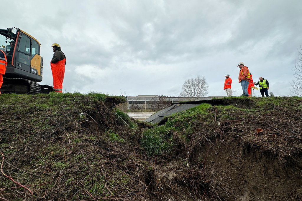 Crews inspect a crack in a levee along the Green River in Tukwila, Wash., Monday, Dec. 15, 2025. (AP Photo/Manuel Valdes)