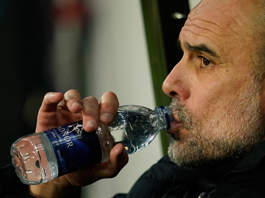 Manchester City's head coach Pep Guardiola drinks water as he attends the start of the English League Cup semifinal first leg soccer match between Newcastle and Manchester City in Newcastle, England, Tuesday, Jan. 13, 2026. (AP Photo/Dave Thompson)