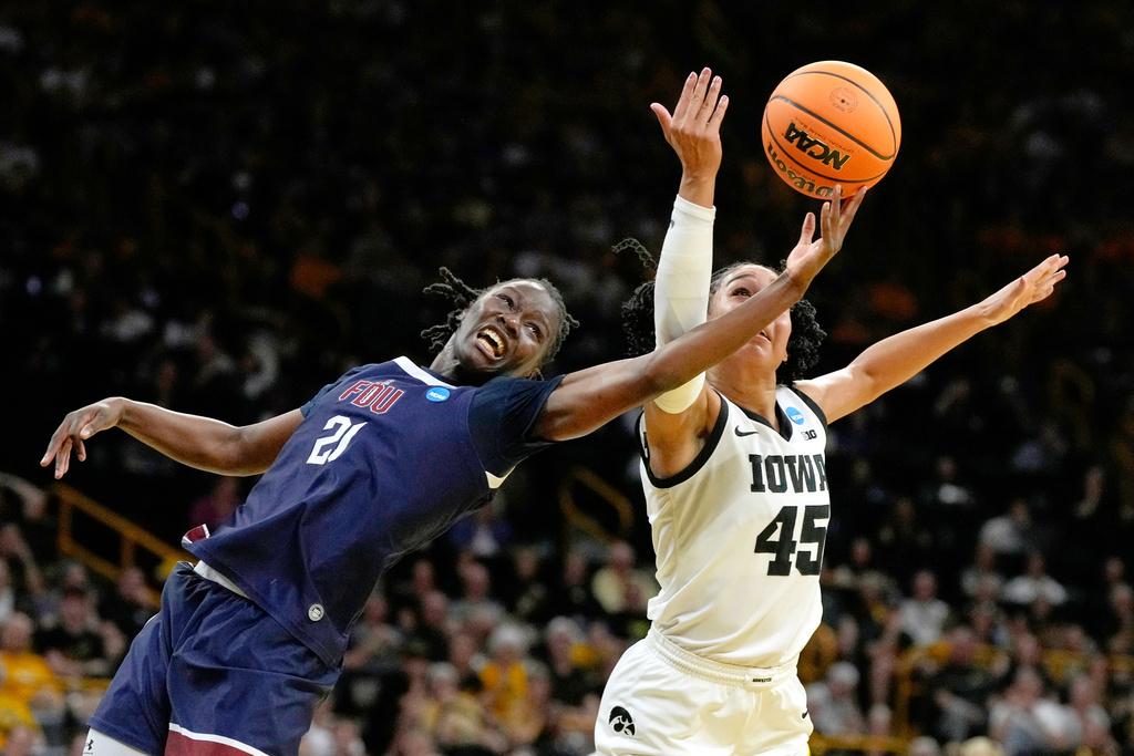 Fairleigh Dickinson guard Rebecca Osei-Owusu (21) fights for a rebound with Iowa forward Hannah Stuelke (45) during the first half in the first round of the NCAA college basketball tournament, Saturday, March 21, 2026, in Iowa City, Iowa. (AP Photo/Charlie Neibergall)