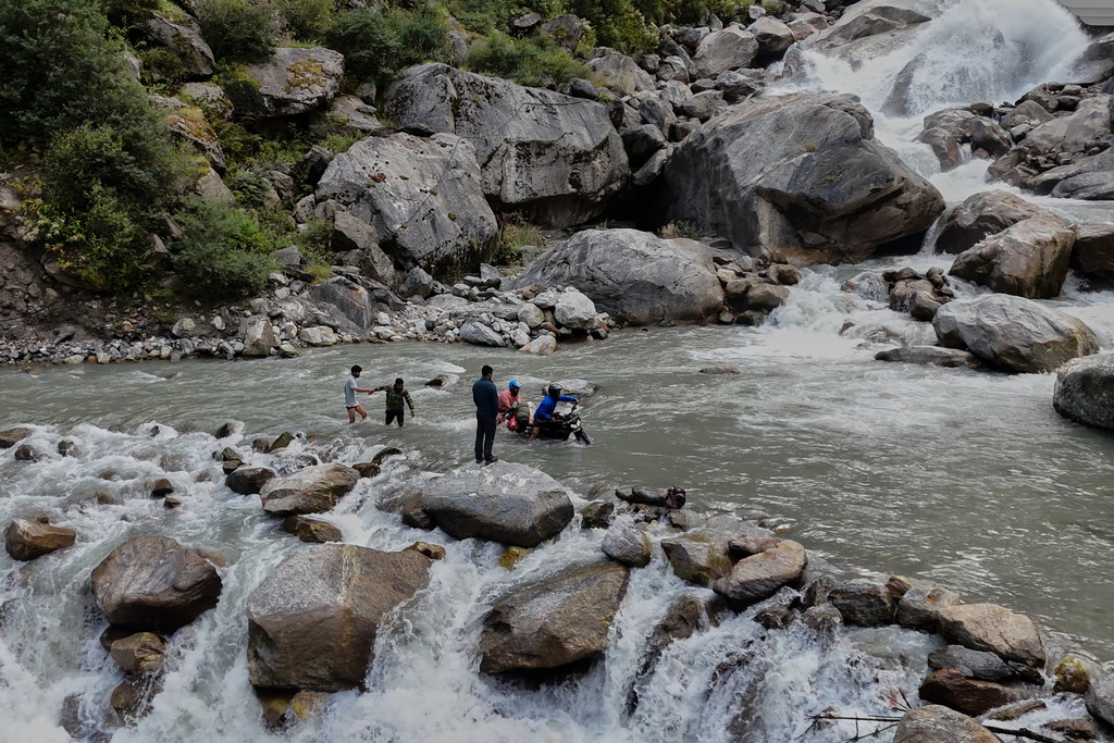 Motorcyclists make their way across a fast-flowing stream, on their way to the Nanda Devi base camp in Rilkot village, in the northern Indian Himalayan state of Uttarakhand, on Oct. 6, 2025. (AP Photo/Satish Sharma)