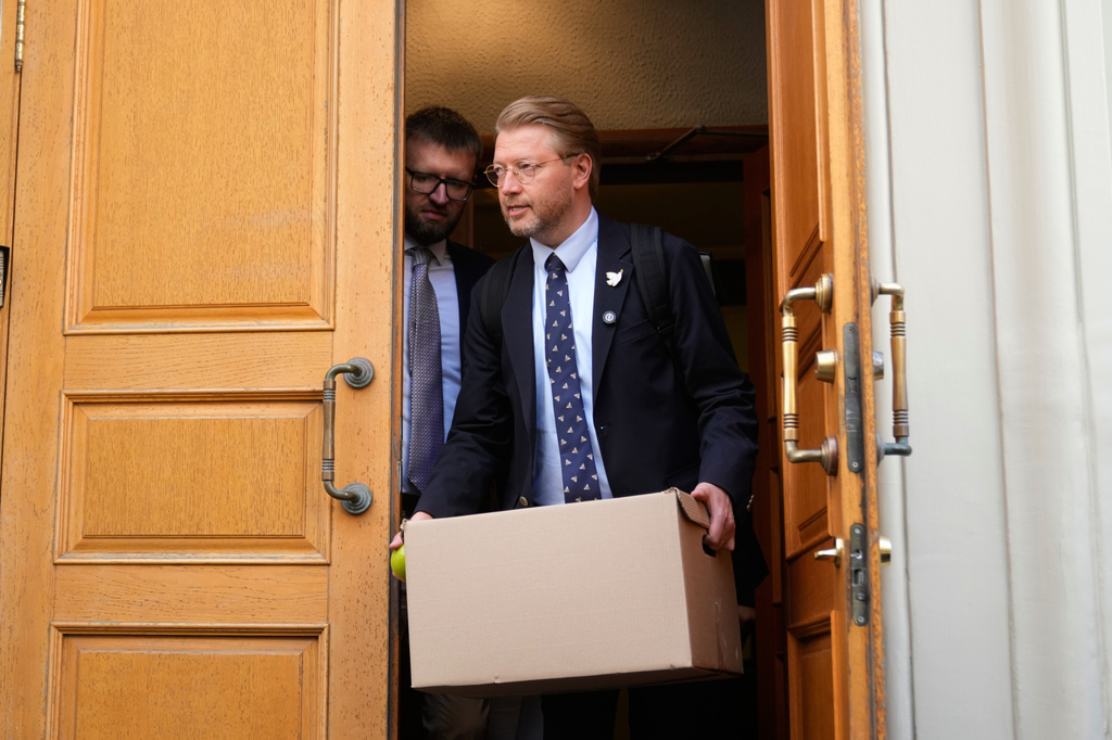Yabloko party leader Nikolai Rybakov carries a box with documents leaving the Russia's Supreme Court after hearing an appeal on a lawsuit to bar the party from the upcoming parliamentary elections, in Moscow, Monday, Aug. 17, 2026. (AP Photo/Pavel Bednyakov)