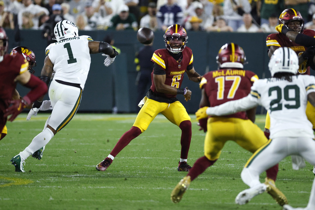 Washington Commanders quarterback Jayden Daniels (5) throws toward wide receiver Terry McLaurin (17) as Green Bay Packers defensive lineman Micah Parsons (1) defends during the first half of an NFL football game Thursday, Sept. 11, 2025, in Green Bay, Wis. (AP Photo/Mike Roemer)
